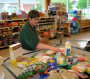 Picture of Abby bagging groceries at the grocery store.