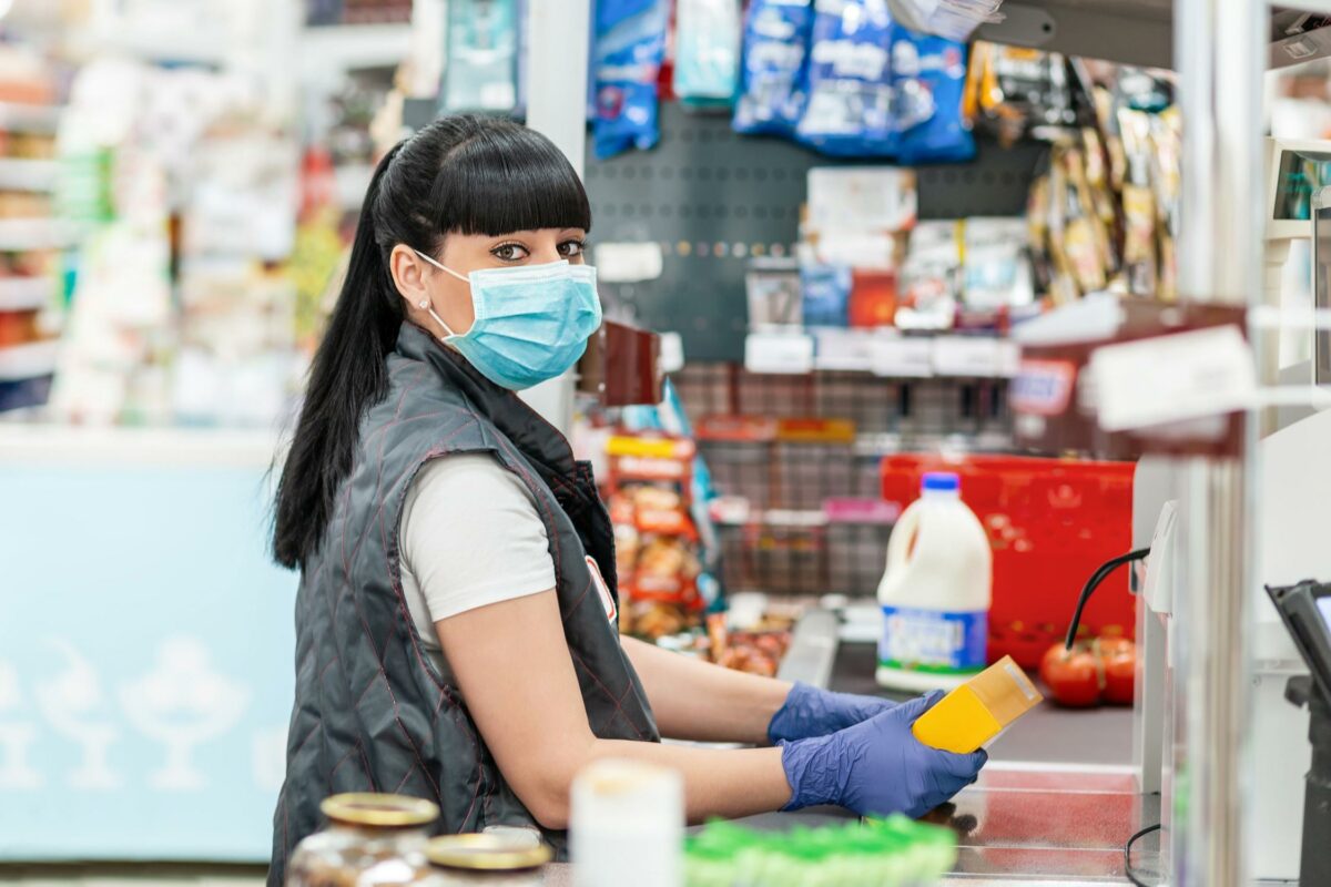 A cashier wearing gloves and a mask