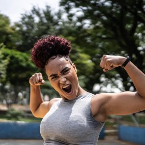 Portrait of a young woman celebrating at a sports court