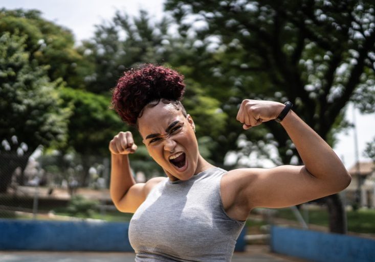 Portrait of a young woman celebrating at a sports court